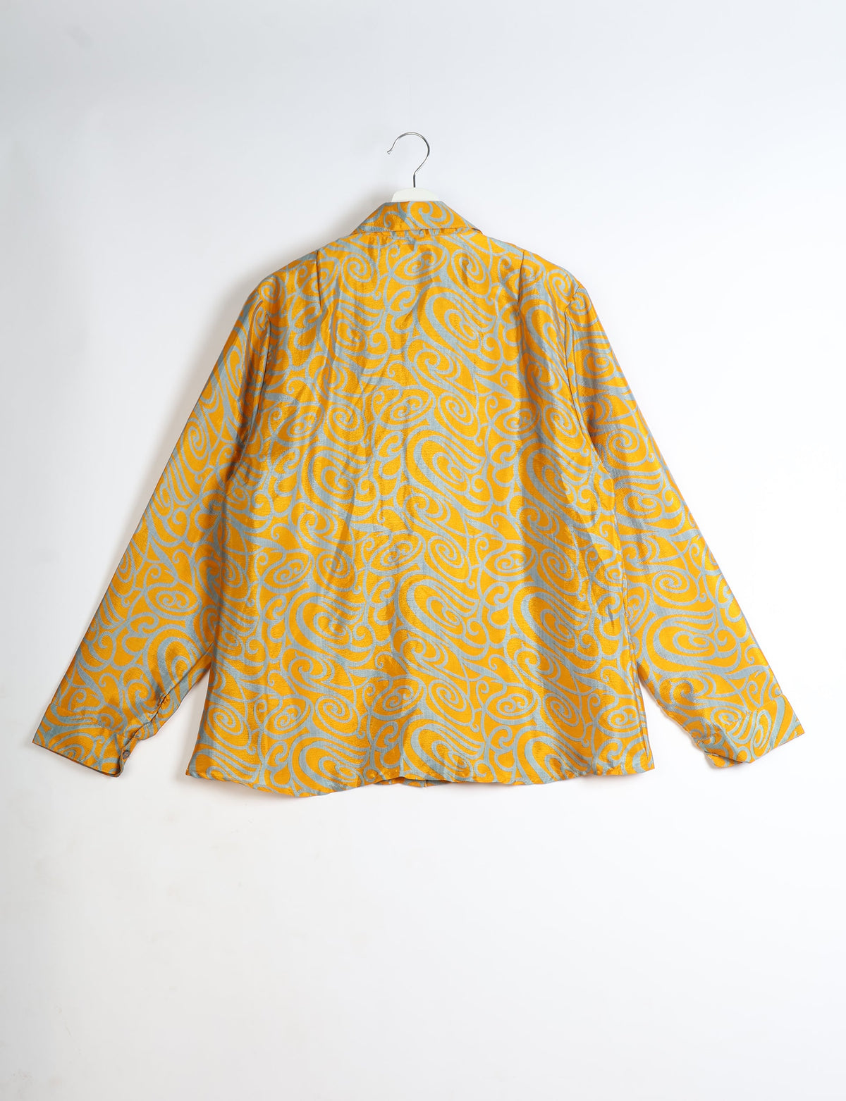 Yellow shirt with gray abstract swirl pattern, long sleeves, collar, shown from back on white hanger against white background