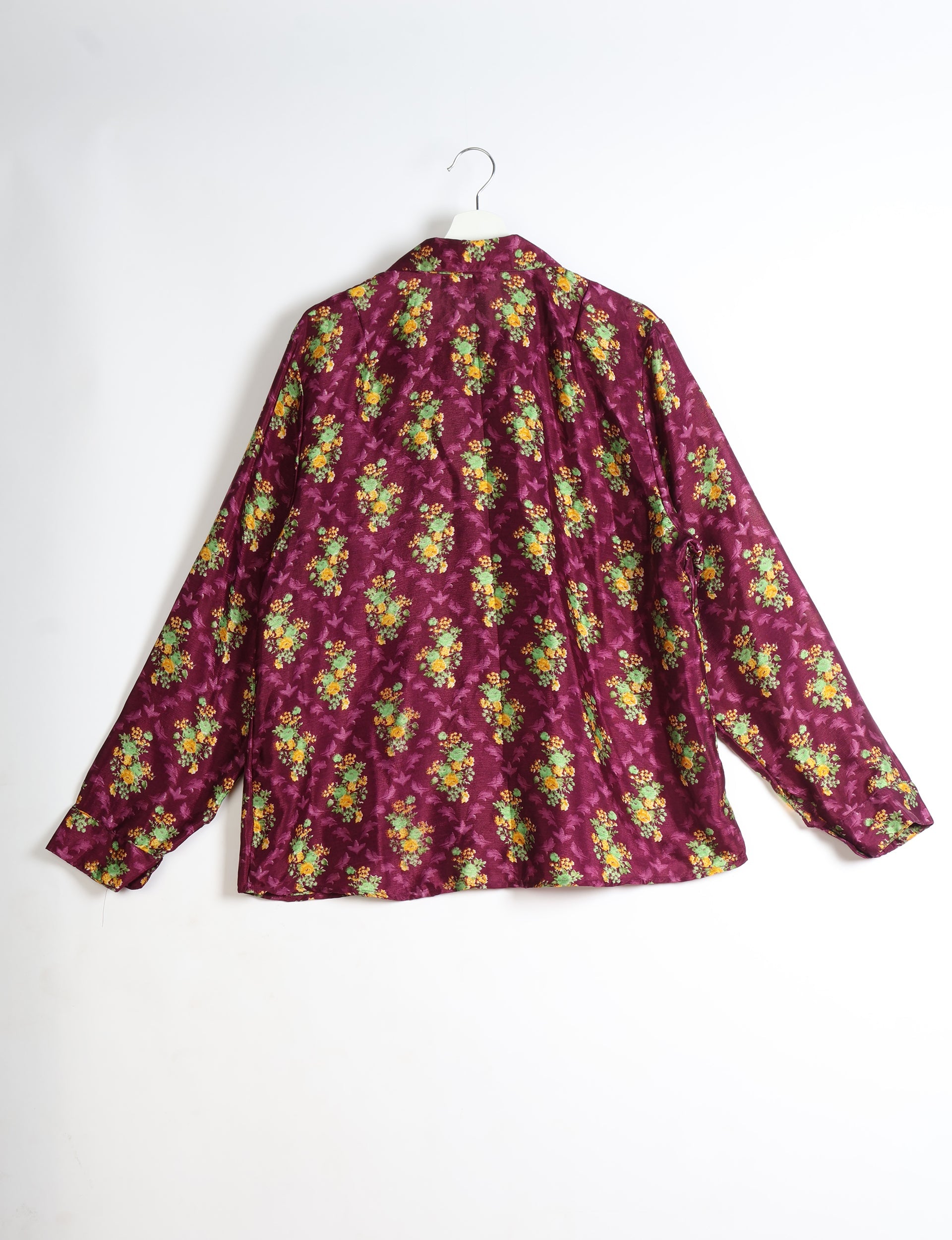 Long-sleeve pink shirt with yellow and green floral tropical pattern, shown from back on white hanger against white background