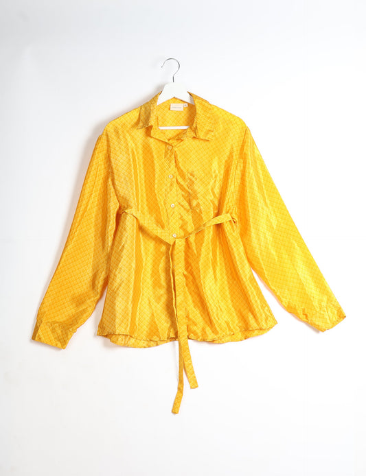 Experience sustainable fashion with our classic slim-fit shirt, crafted with ethical and green values. The shirt, designed for minimal waste, features a tie-up waist belt or neck tie, semi-spread collar, and regular shirt cuffs. Versatile and eco-friendly, wear it tucked in, unbuttoned over a tank top, or knotted at the waist for a unique style.