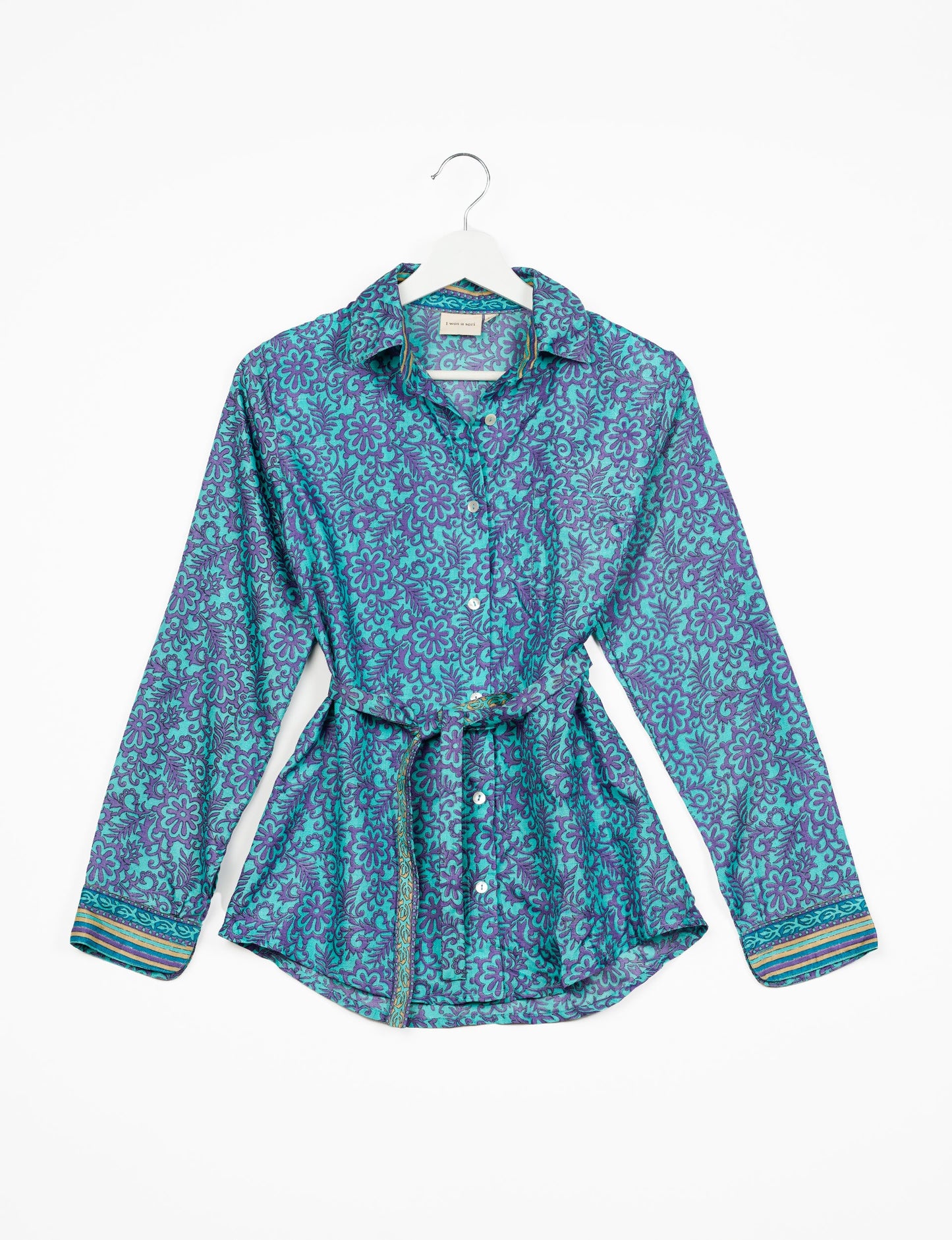 Experience sustainable fashion with our classic slim-fit shirt, crafted with ethical and green values. The shirt, designed for minimal waste, features a tie-up waist belt or neck tie, semi-spread collar, and regular shirt cuffs. Versatile and eco-friendly, wear it tucked in, unbuttoned over a tank top, or knotted at the waist for a unique style.