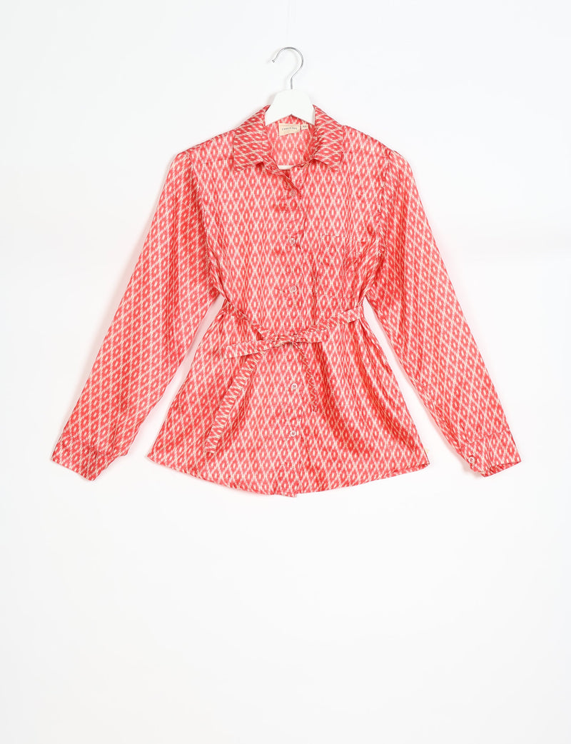 Pink geometric patterned long-sleeve button-up shirt with collar and waist tie, hanging on white hanger, size XS visible on tag