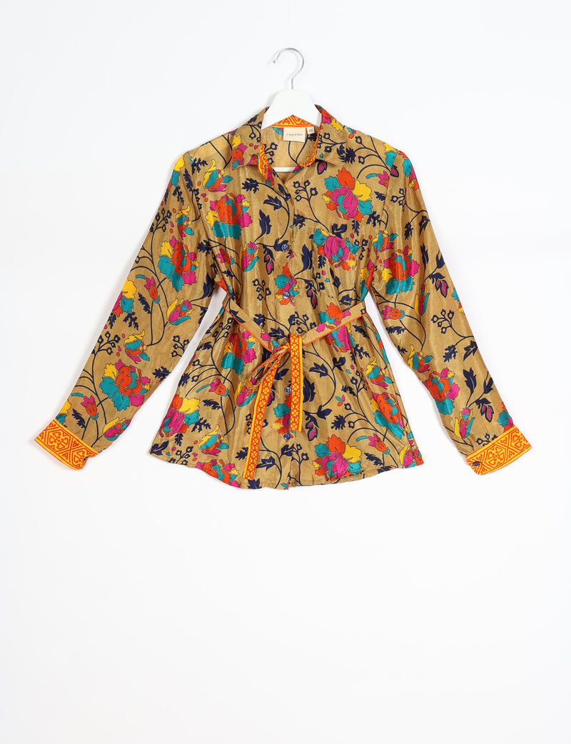 Yellow long-sleeve button-up shirt with multicolor floral print, orange patterned cuffs, and matching belt, front view on hanger