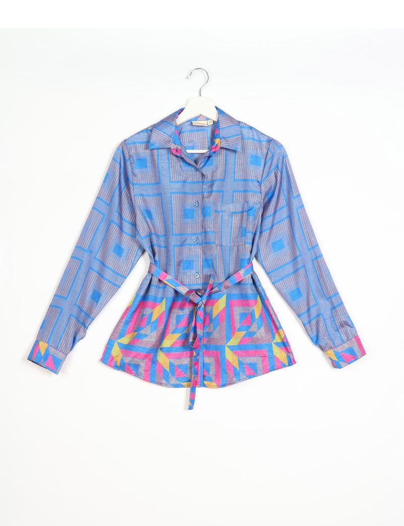 Blue geometric patterned long-sleeve shirt with collar and waist tie, shown hanging on a white hanger