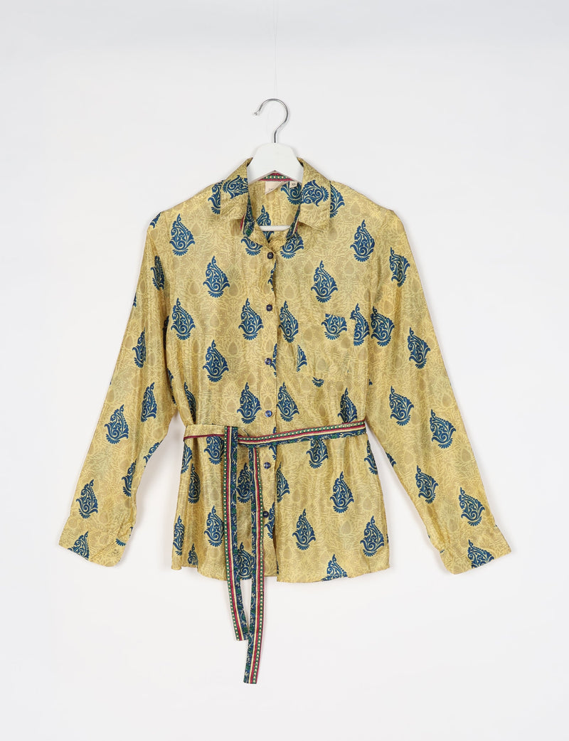 Yellow button-up shirt with blue paisley print, long sleeves, chest pocket, and multicolor striped belt, hanging on white hanger