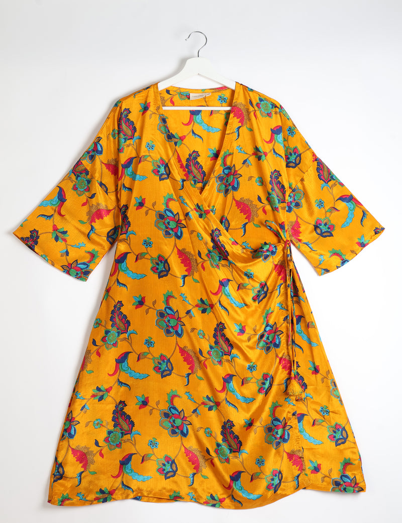 Yellow tropical wrap coat with blue and red floral print, wide sleeves, and side tie, hanging on white hanger