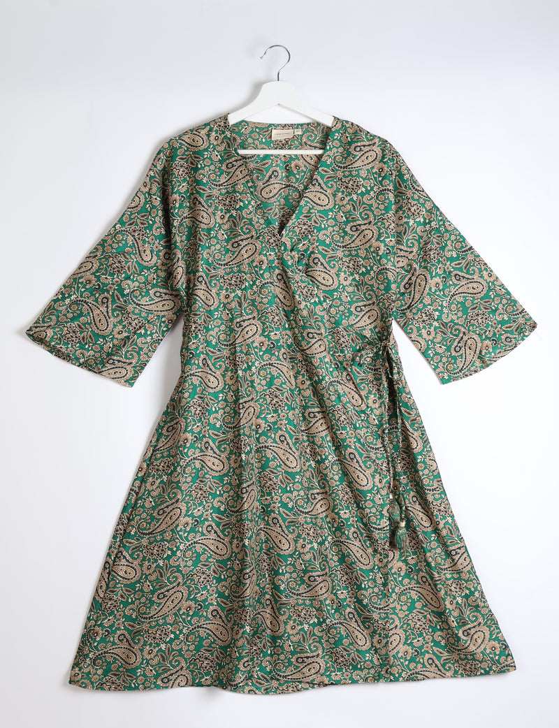 Green paisley patterned wrap coat with wide sleeves hanging on white hanger against white background