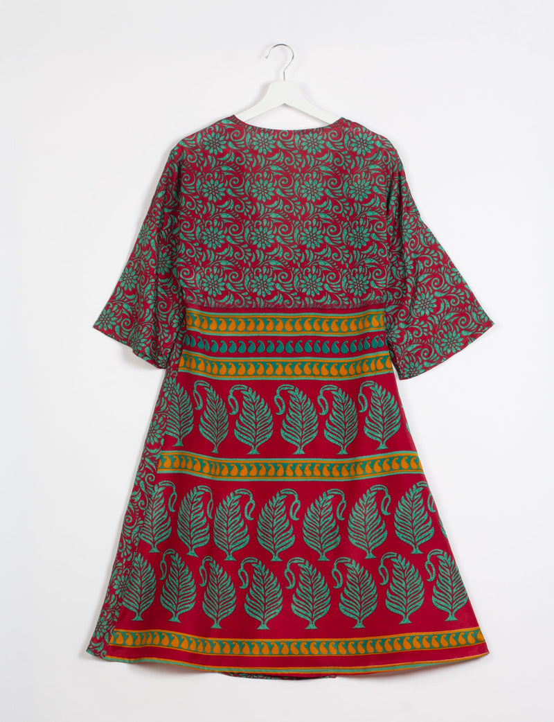 Red coat with green floral and leaf patterns, orange and green decorative horizontal stripes, shown from back on white hanger