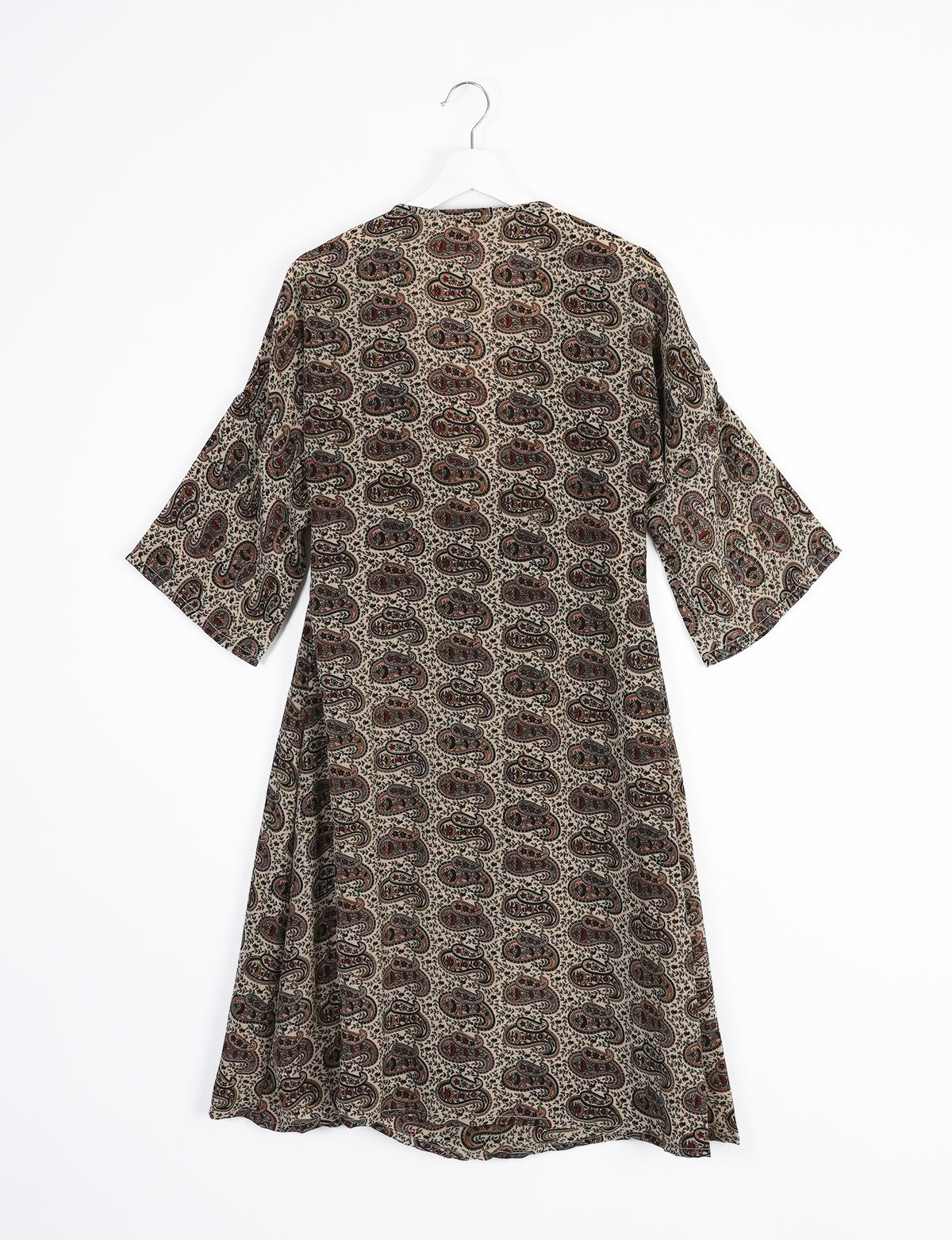 Brown coat with eclectic paisley pattern in black and red, wide sleeves, shown from back on white hanger against white background