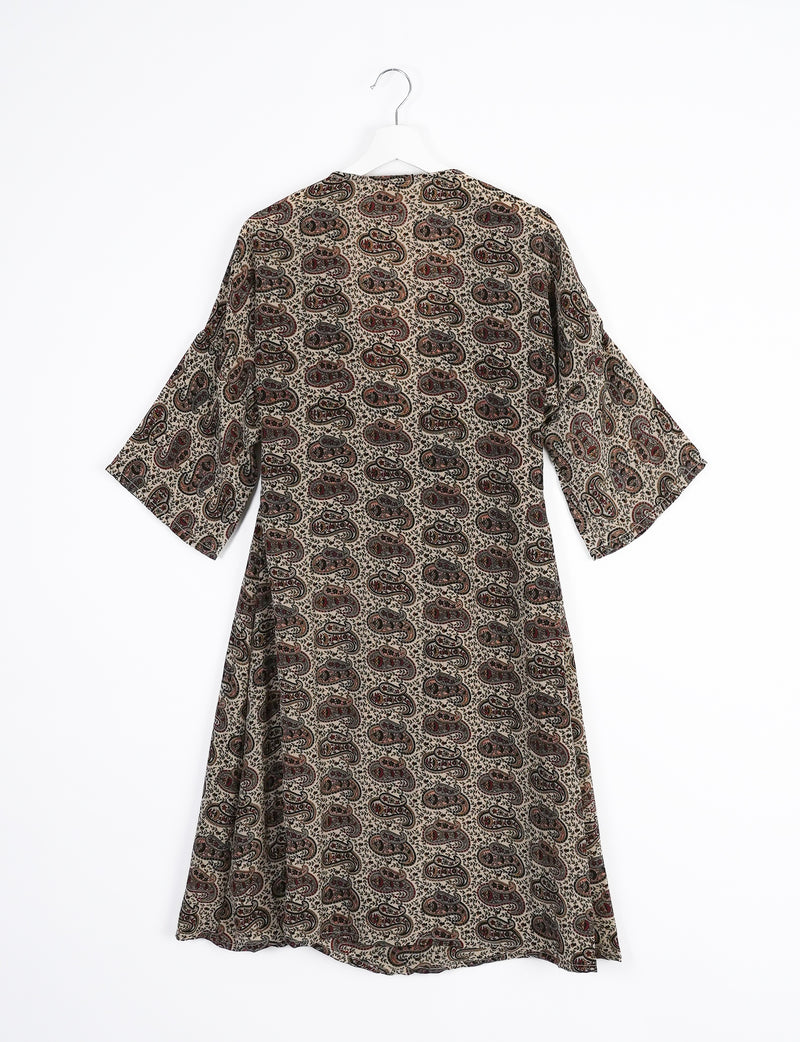 Brown coat with eclectic paisley pattern in black and red, wide sleeves, shown from back on white hanger against white background