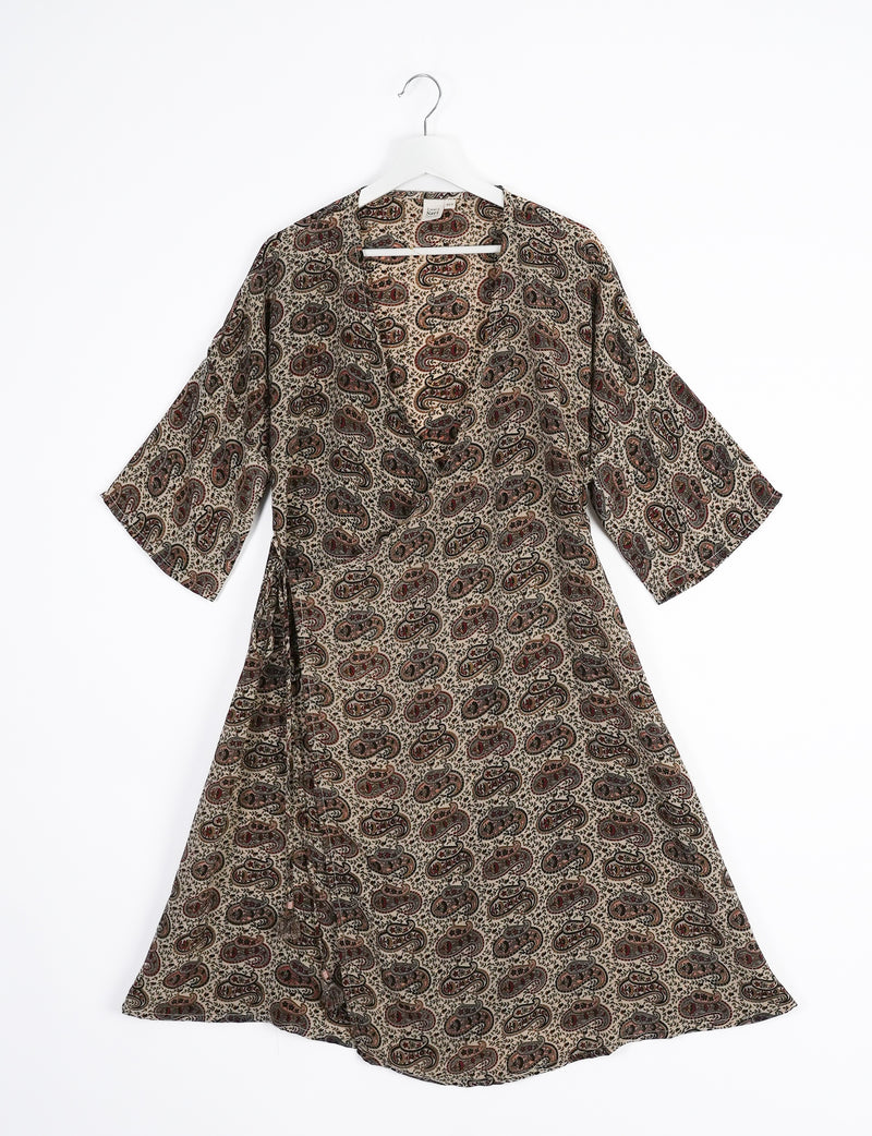 Brown paisley patterned wrap coat with wide sleeves hanging on white hanger against white background
