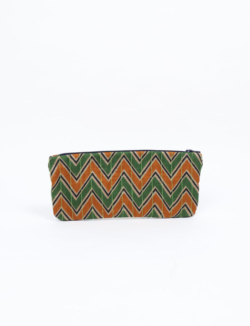 Quilted pencil pouch with green, orange, and beige chevron pattern, navy zipper, front view, flat on white background