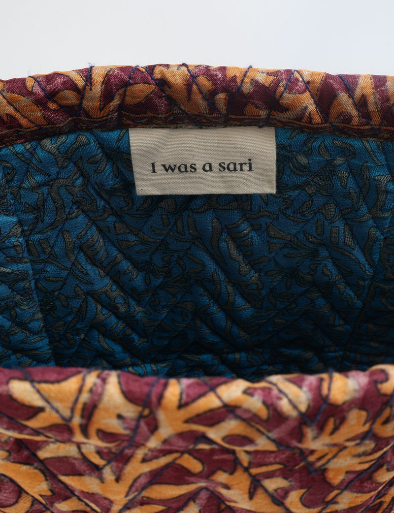 Quilted tote bag interior showing blue and red tropical patterned fabric with label reading "I was a sari"