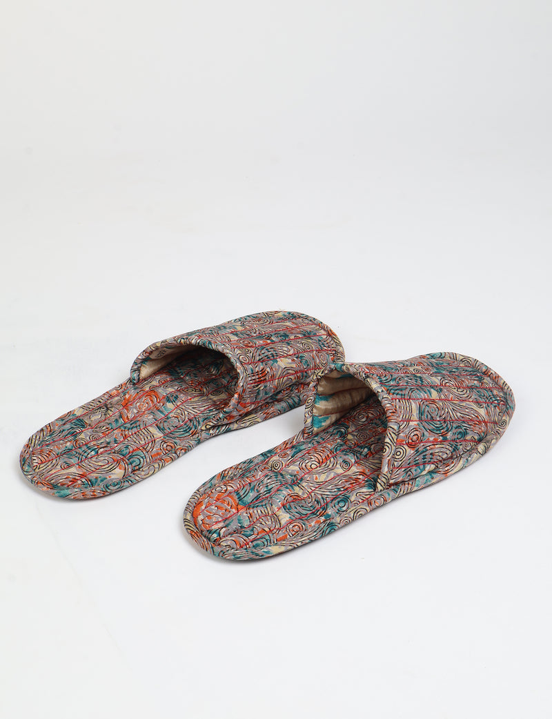 Beige quilted slippers with multicolor paisley pattern, open back, flat sole, shown from top angle on white background