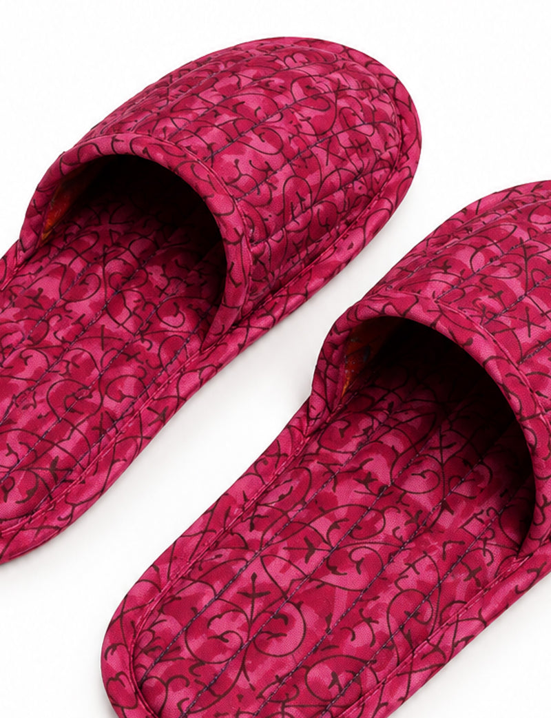 Blue quilted slippers with paisley pattern in shades of purple, green, and pink, shown from top view on white background