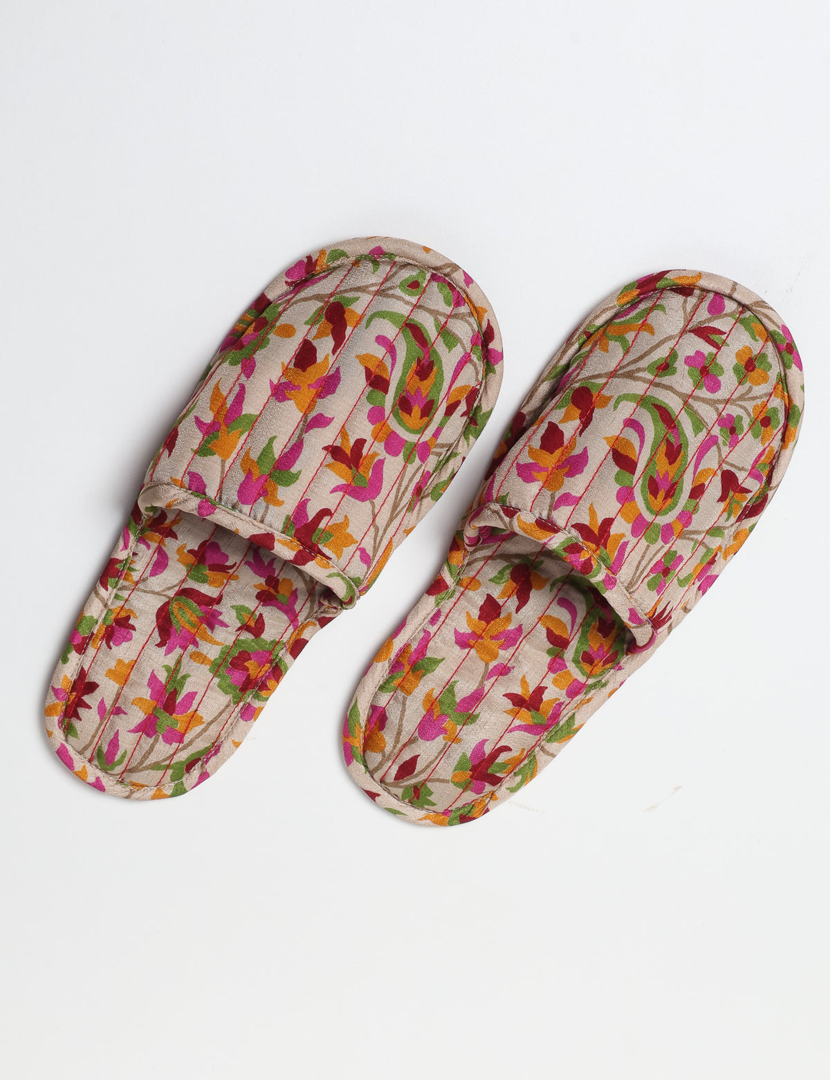 Blue quilted slippers with paisley pattern, open back, and cushioned footbed, shown flat on white background