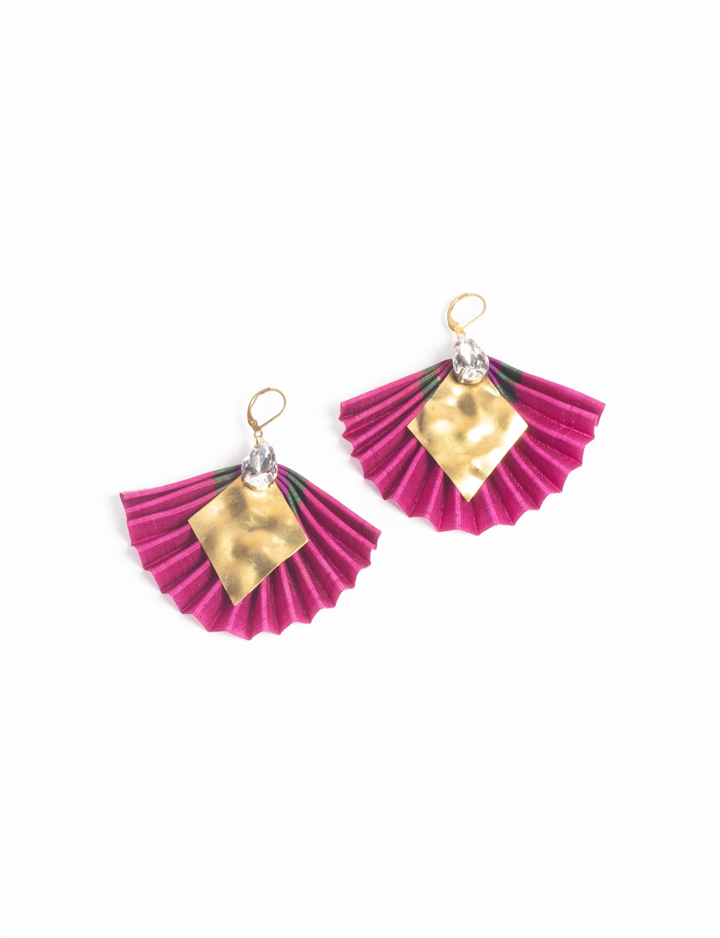 Elevate your style sustainably with our PLEATED EARRINGS – a fusion of ethical fashion and eco-conscious design. Created from pre-loved saris using heat set pleats, these earrings embody zero waste clothing and upcycled fashion. Fastened with hooks, adorned with a diamond-shaped metallic plate and a special drop-shaped jewel. Hypoallergy tested metal hooks, nickel, and lead-free, making them a conscious and skin-friendly accessory.