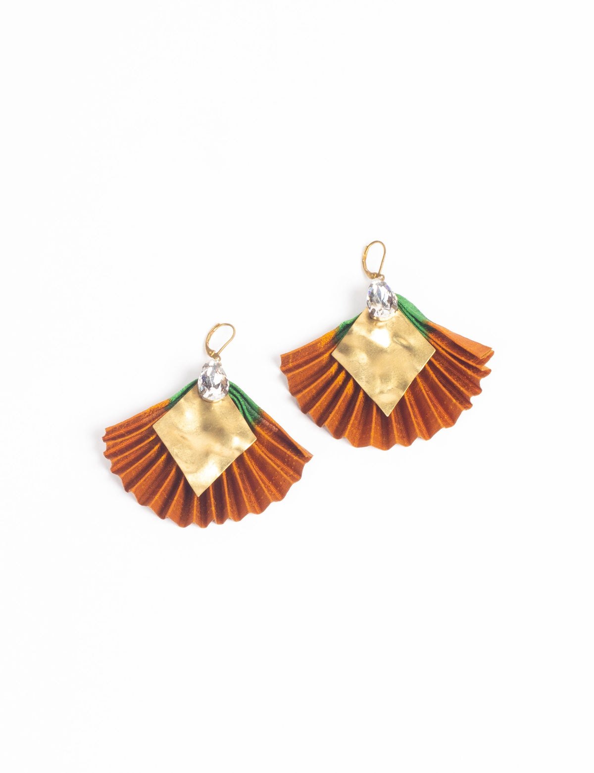 Pair of pleated earrings with orange fabric, green accents, gold diamond-shaped metal, and clear teardrop crystals, flat lay view
