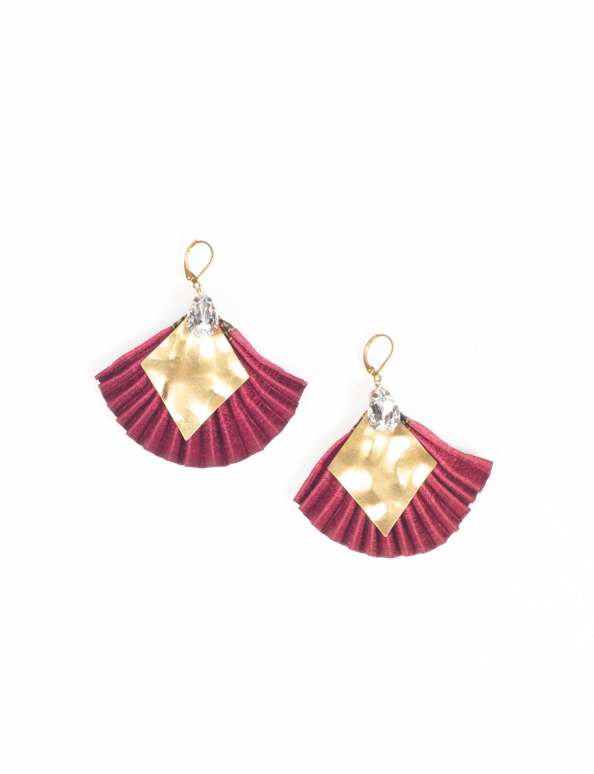 Pink pleated fabric earrings with hammered gold diamond shapes and clear teardrop crystals, shown flat on white background