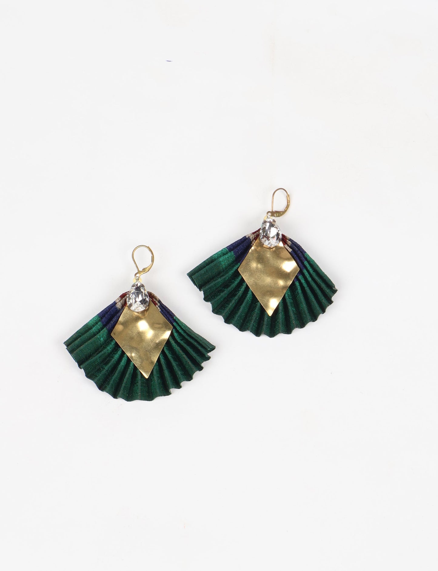 Elevate your style sustainably with our PLEATED EARRINGS – a fusion of ethical fashion and eco-conscious design. Created from pre-loved saris using heat set pleats, these earrings embody zero waste clothing and upcycled fashion. Fastened with hooks, adorned with a diamond-shaped metallic plate and a special drop-shaped jewel. Hypoallergy tested metal hooks, nickel, and lead-free, making them a conscious and skin-friendly accessory.