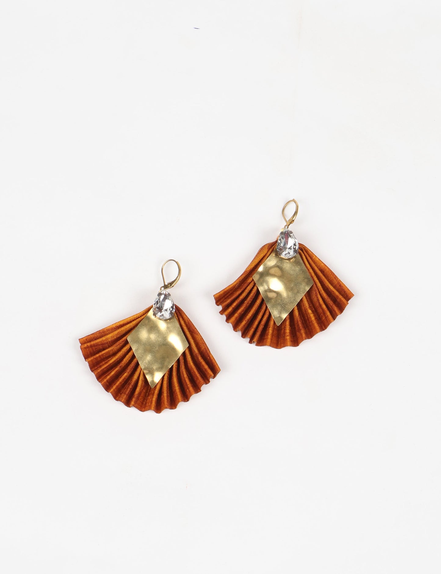 Elevate your style sustainably with our PLEATED EARRINGS – a fusion of ethical fashion and eco-conscious design. Created from pre-loved saris using heat set pleats, these earrings embody zero waste clothing and upcycled fashion. Fastened with hooks, adorned with a diamond-shaped metallic plate and a special drop-shaped jewel. Hypoallergy tested metal hooks, nickel, and lead-free, making them a conscious and skin-friendly accessory.
