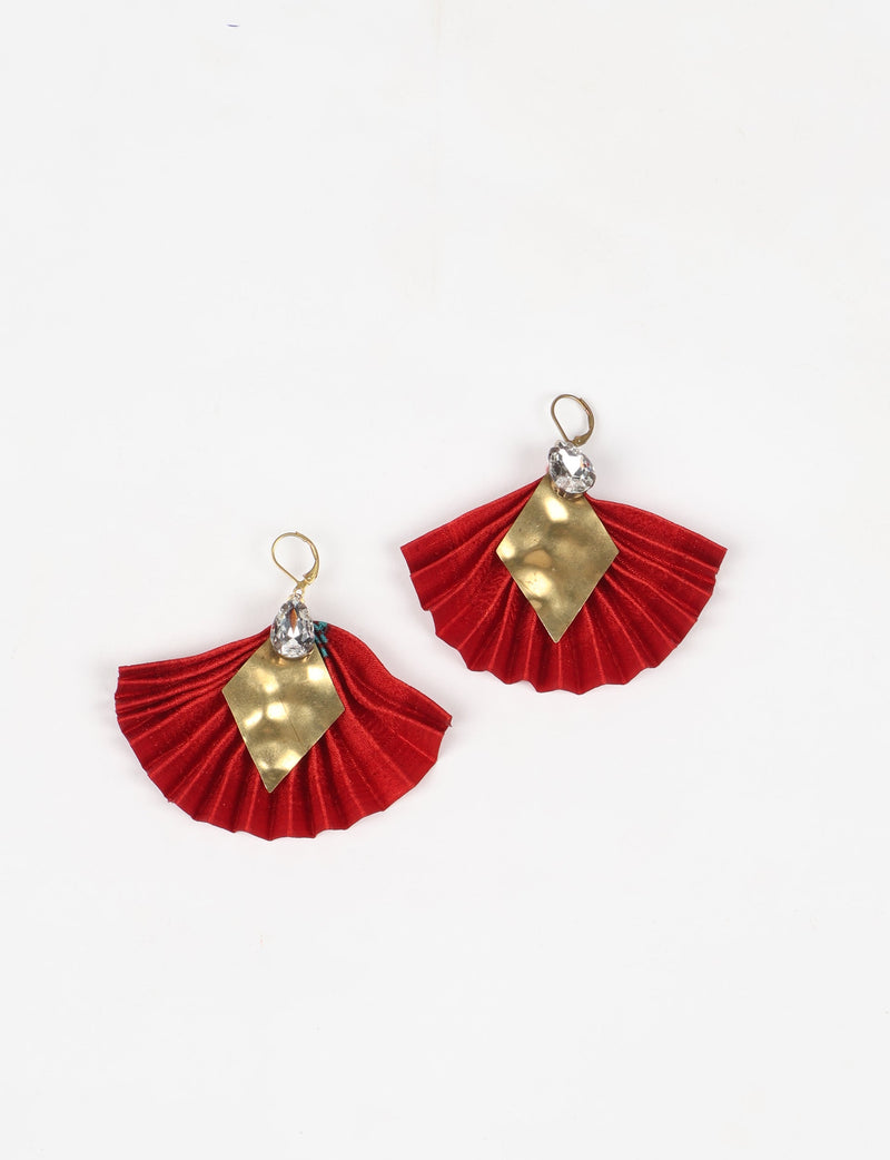 Red pleated fabric earrings with hammered gold diamond-shaped metal and clear teardrop crystals, shown flat on white background