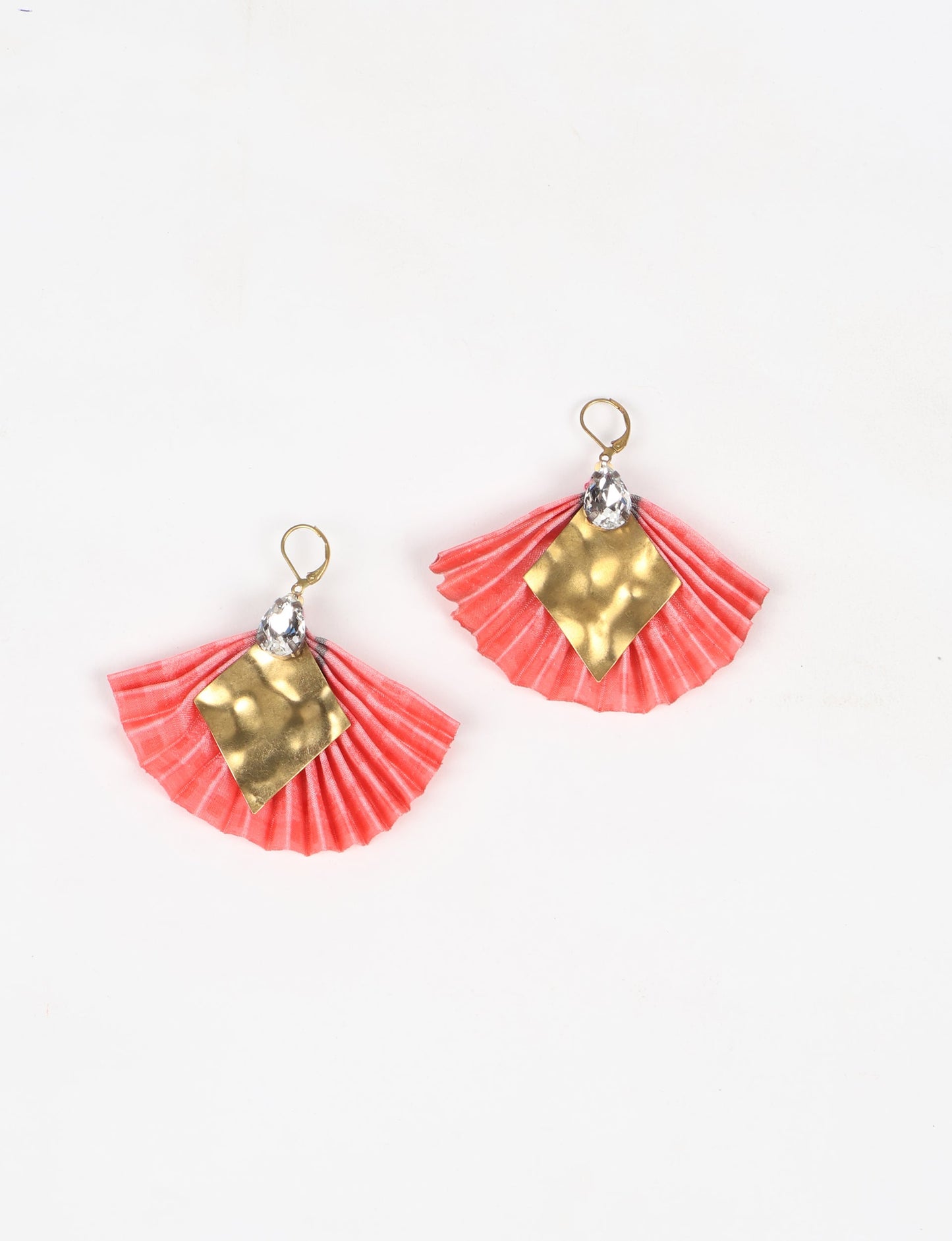 Elevate your style sustainably with our PLEATED EARRINGS – a fusion of ethical fashion and eco-conscious design. Created from pre-loved saris using heat set pleats, these earrings embody zero waste clothing and upcycled fashion. Fastened with hooks, adorned with a diamond-shaped metallic plate and a special drop-shaped jewel. Hypoallergy tested metal hooks, nickel, and lead-free, making them a conscious and skin-friendly accessory.