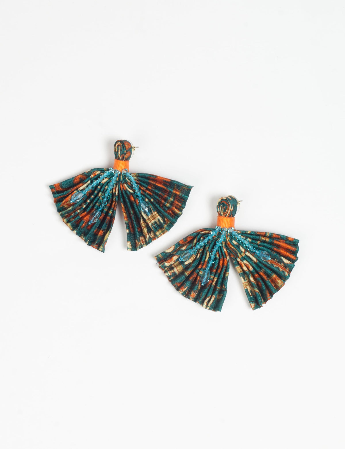 Pleated fabric earrings with green, orange, and beige micro design, blue bead embellishments, and orange band, flat lay view