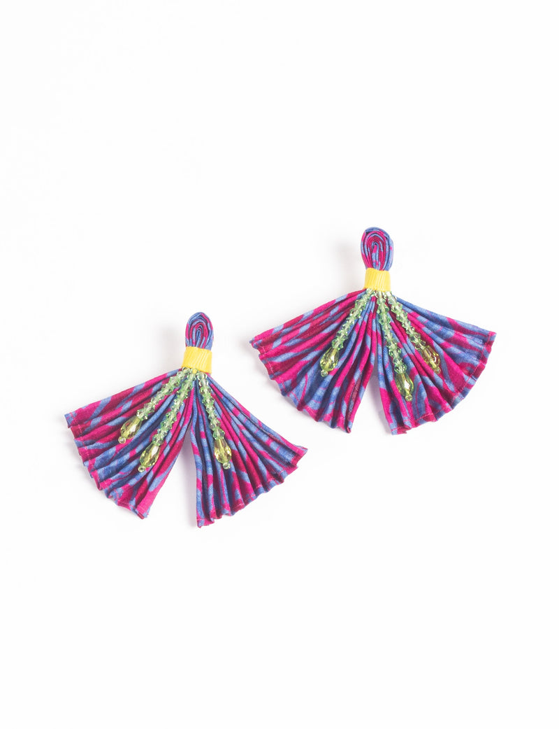 Pleated earrings in pink and blue abstract pattern with yellow band and green bead embellishments, flat lay view