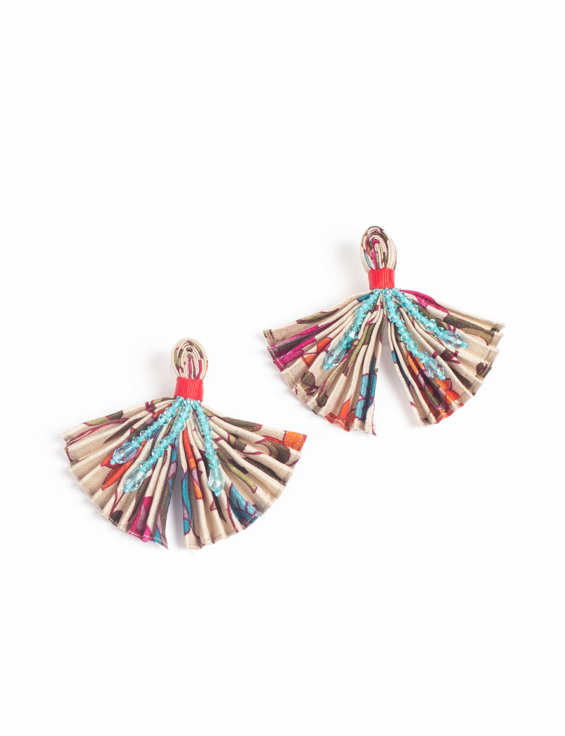 Pink abstract pleated fabric earrings with blue bead embellishments and red thread detail, shown flat on white background