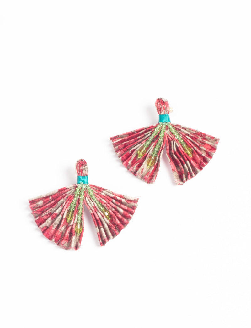 Pink abstract pleated fabric earrings with green bead embellishments and turquoise thread detail, shown flat on white background