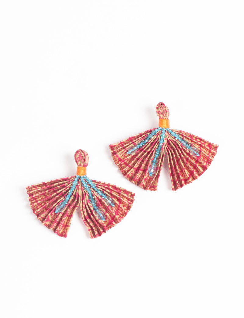 Red and beige pleated fabric earrings with blue bead embellishments and orange thread detail, shown flat on white background