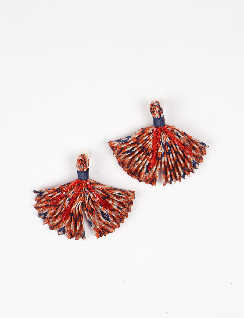 Pleated fabric earrings in orange, navy, and white abstract pattern with red bead embellishments, shown flat on white background