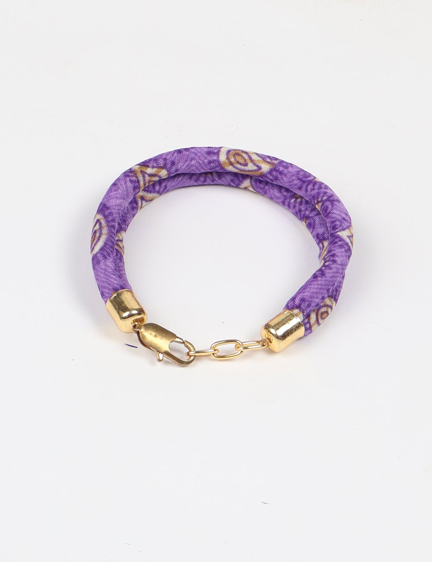 A close-up image of a hand wearing the Sari Rope bracelet, showcasing its colorful threads and unique design. This accessory embodies ethical fashion and sustainability, crafted from repurposed saris for a stylish and eco-conscious statement.