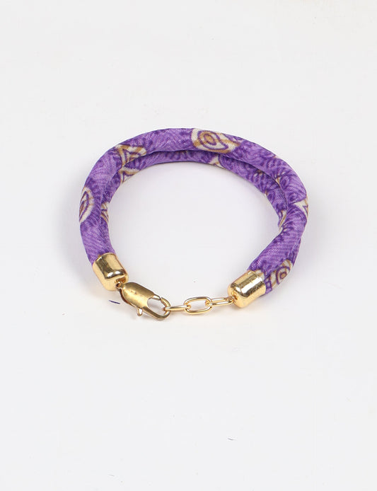 A close-up image of a hand wearing the Sari Rope bracelet, showcasing its colorful threads and unique design. This accessory embodies ethical fashion and sustainability, crafted from repurposed saris for a stylish and eco-conscious statement.