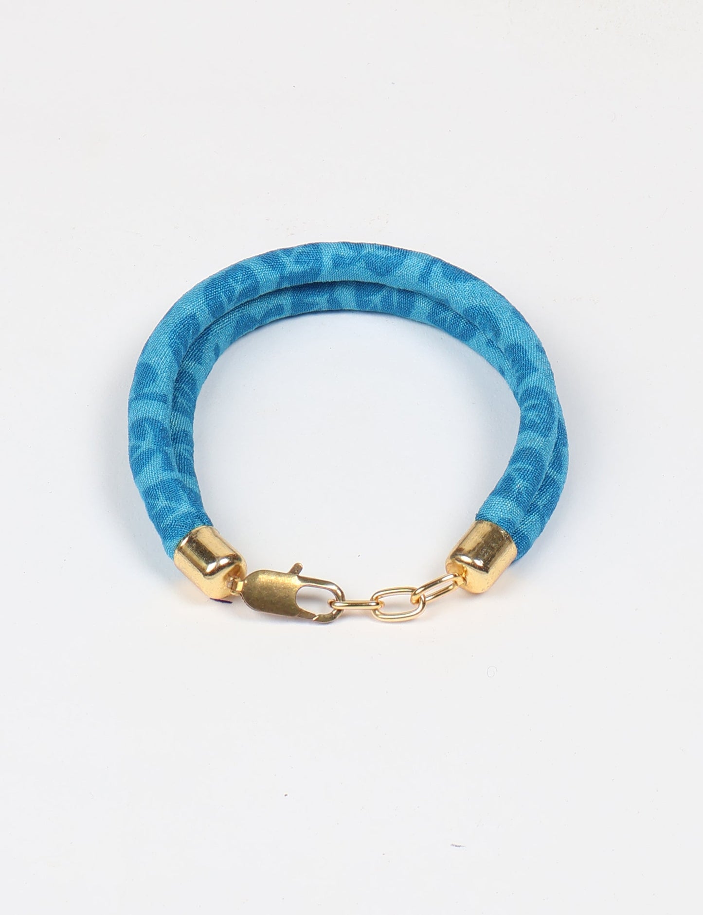 A close-up image of a hand wearing the Sari Rope bracelet, showcasing its colorful threads and unique design. This accessory embodies ethical fashion and sustainability, crafted from repurposed saris for a stylish and eco-conscious statement.