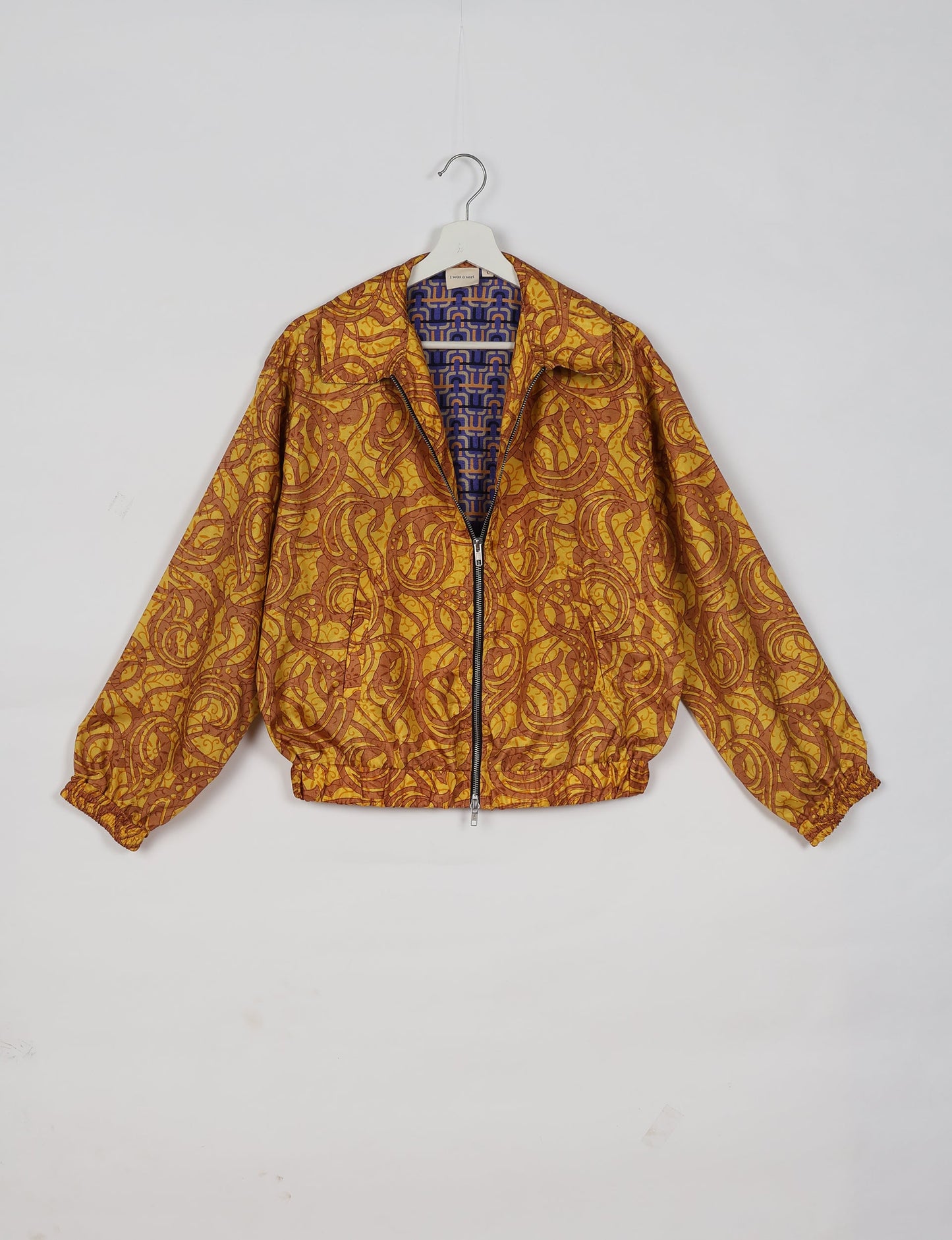 Upcycled Bomber Jacket made from recycled sari materials, featuring a cute cropped shape, elasticated hem and cuffs, and contrast sari print lining. Sustainable apparel promoting eco-friendly fashion and ethical clothing.