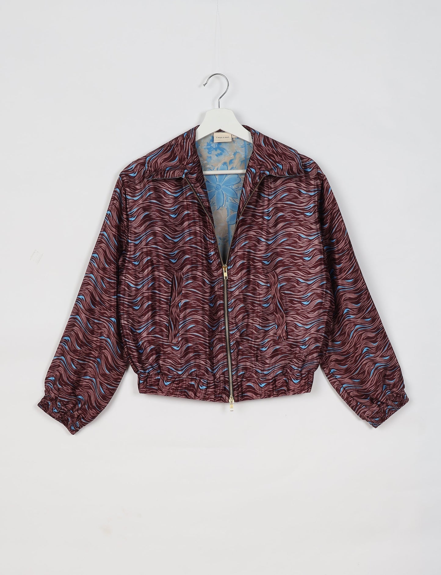 Upcycled Bomber Jacket made from recycled sari materials, featuring a cute cropped shape, elasticated hem and cuffs, and contrast sari print lining. Sustainable apparel promoting eco-friendly fashion and ethical clothing.