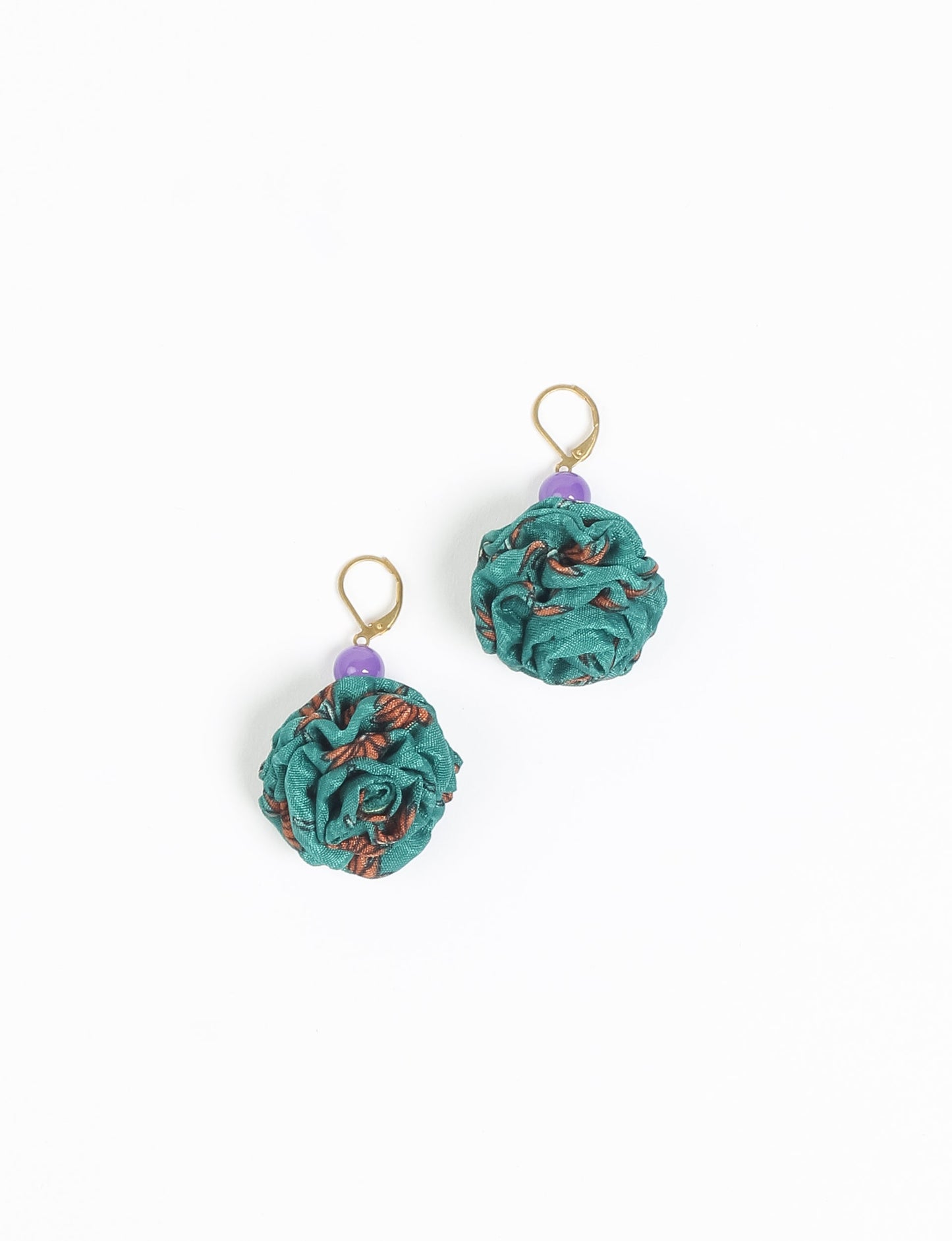 Elevate your style with our Ruffle Earrings, adorned with unique ruffle ball florets crafted from upcycled Indian saris using the traditional Aari embroidery technique. These sustainable earrings feature two glass beads and nickel-free, hypoallergenic metal hooks. Embrace ethical and green fashion with these statement pieces.