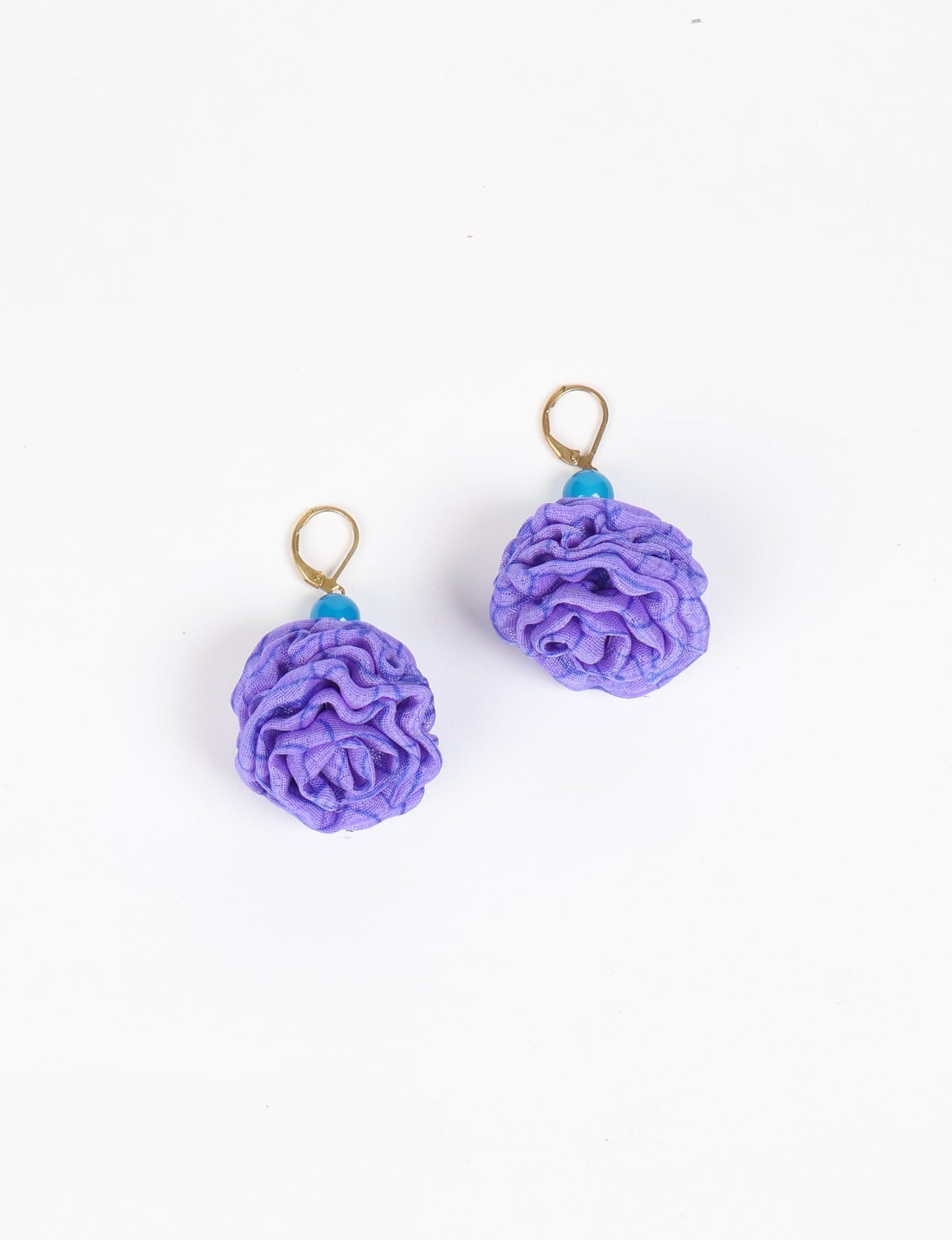 Elevate your style with our Ruffle Earrings, adorned with unique ruffle ball florets crafted from upcycled Indian saris using the traditional Aari embroidery technique. These sustainable earrings feature two glass beads and nickel-free, hypoallergenic metal hooks. Embrace ethical and green fashion with these statement pieces.