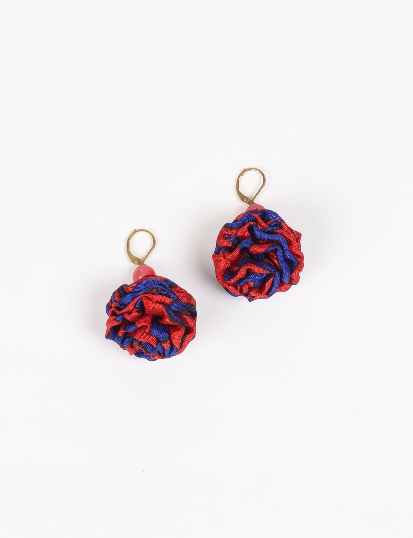 Elevate your style with our Ruffle Earrings, adorned with unique ruffle ball florets crafted from upcycled Indian saris using the traditional Aari embroidery technique. These sustainable earrings feature two glass beads and nickel-free, hypoallergenic metal hooks. Embrace ethical and green fashion with these statement pieces.