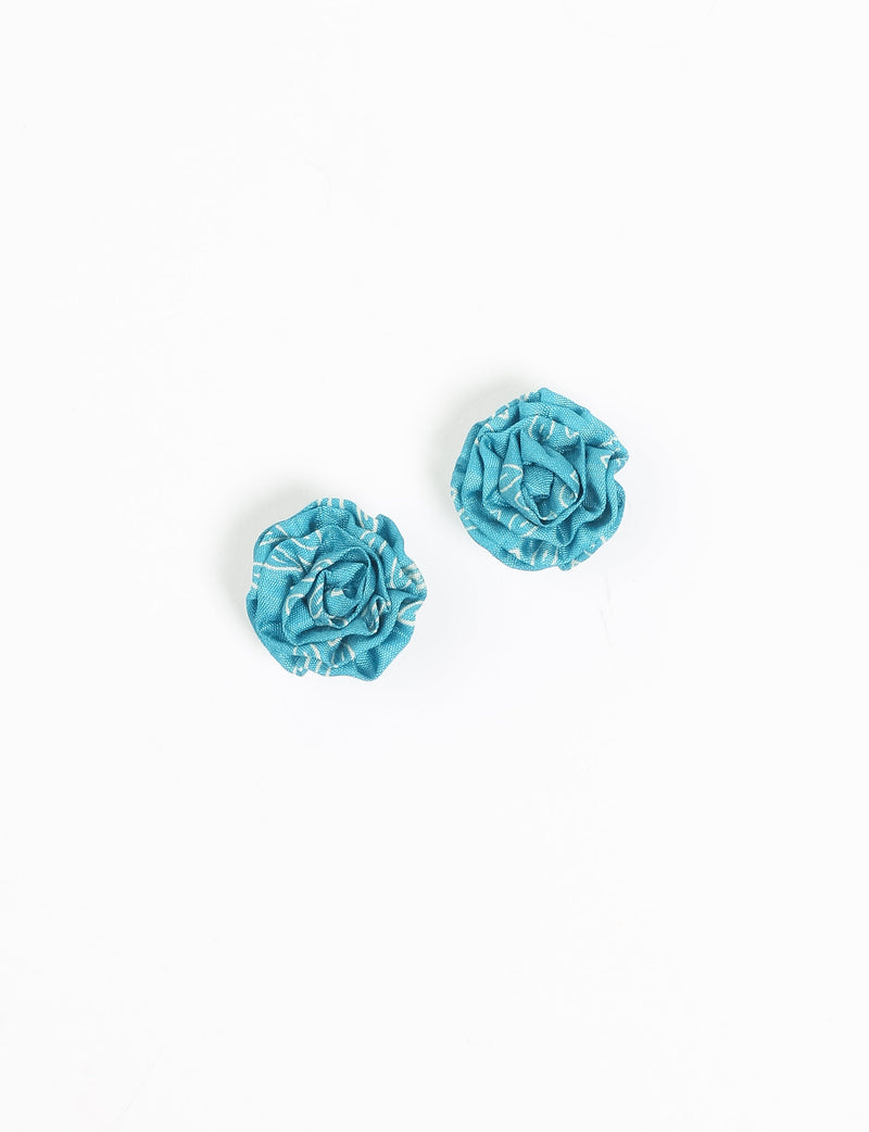 Pair of blue fabric ruffle earrings with white ethnic pattern, flat lay on white background