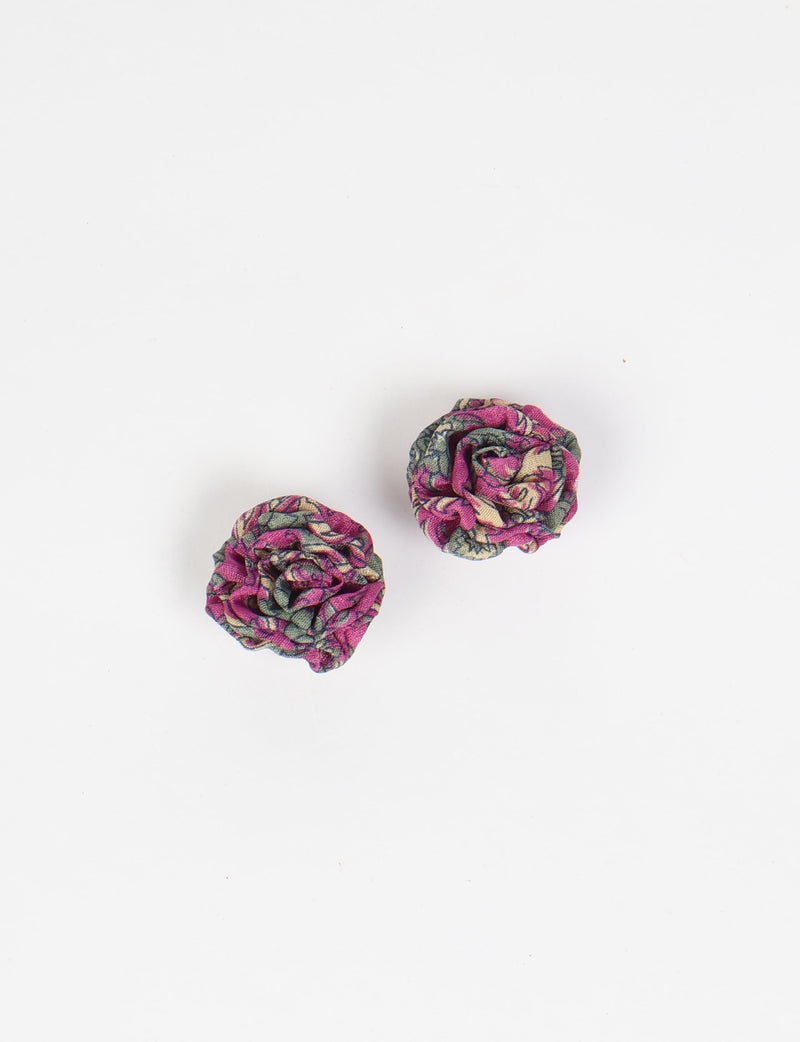 Pair of pink abstract ruffle fabric earrings with green and beige floral pattern, flat lay on white background