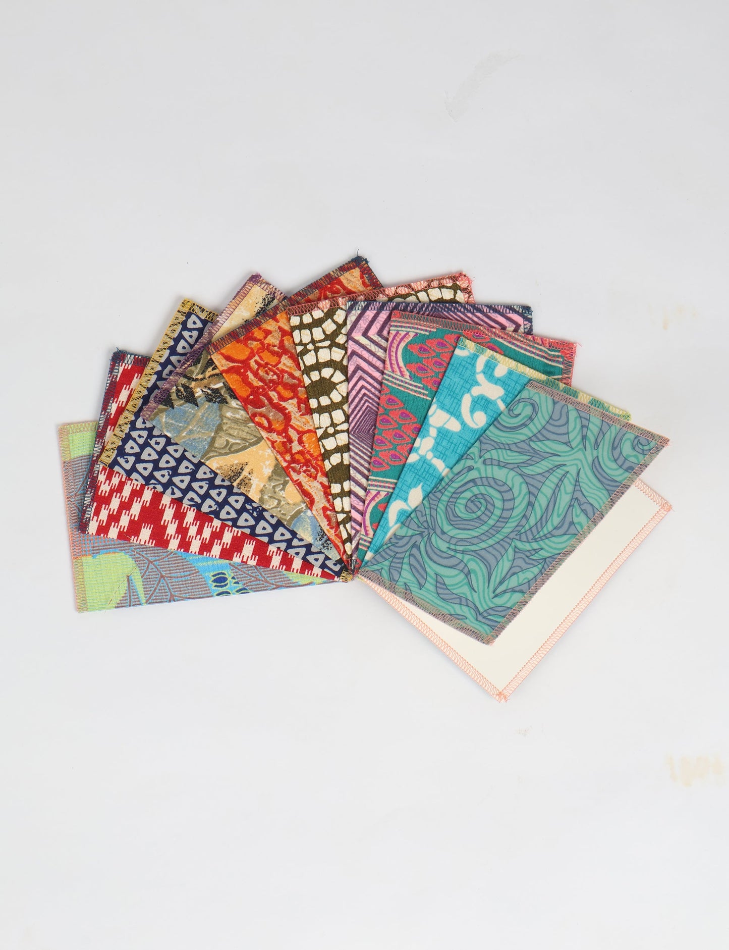 Sustainably crafted FOLDED POSTCARD SET, 10 assorted pieces made with 100% recycled paper and printed sari fabric sourced from Mumbai markets. Eco-friendly with contrast overlock edging. Envelopes included for eco-conscious gratitude and cheerful messages to loved ones.