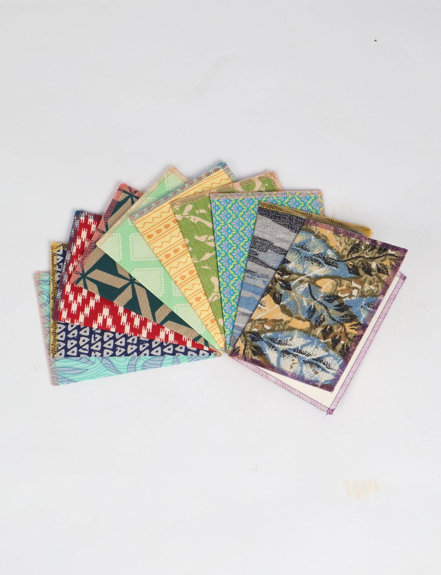 Sustainably crafted FOLDED POSTCARD SET, 10 assorted pieces made with 100% recycled paper and printed sari fabric sourced from Mumbai markets. Eco-friendly with contrast overlock edging. Envelopes included for eco-conscious gratitude and cheerful messages to loved ones.