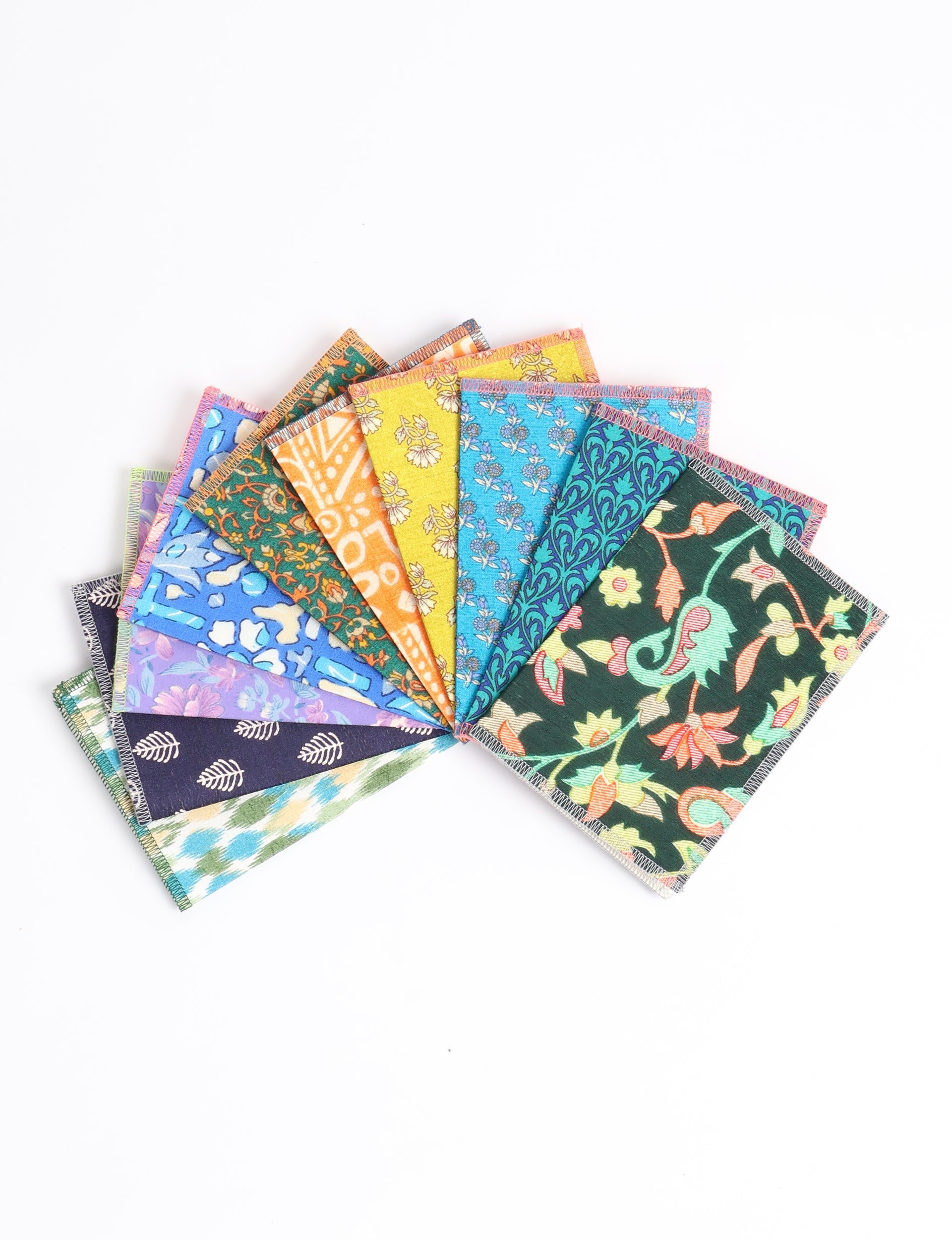 Folded postcard set with colorful upcycled sari fabric covers, showing floral and geometric patterns, arranged fanned on white background