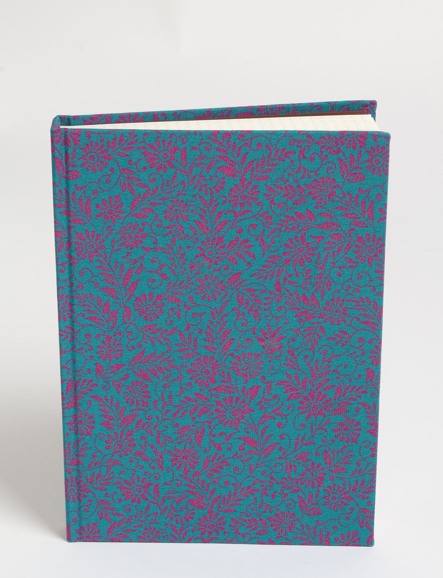 A5 hard cover notebook with blue fabric cover featuring pink floral and leaf pattern, shown standing upright