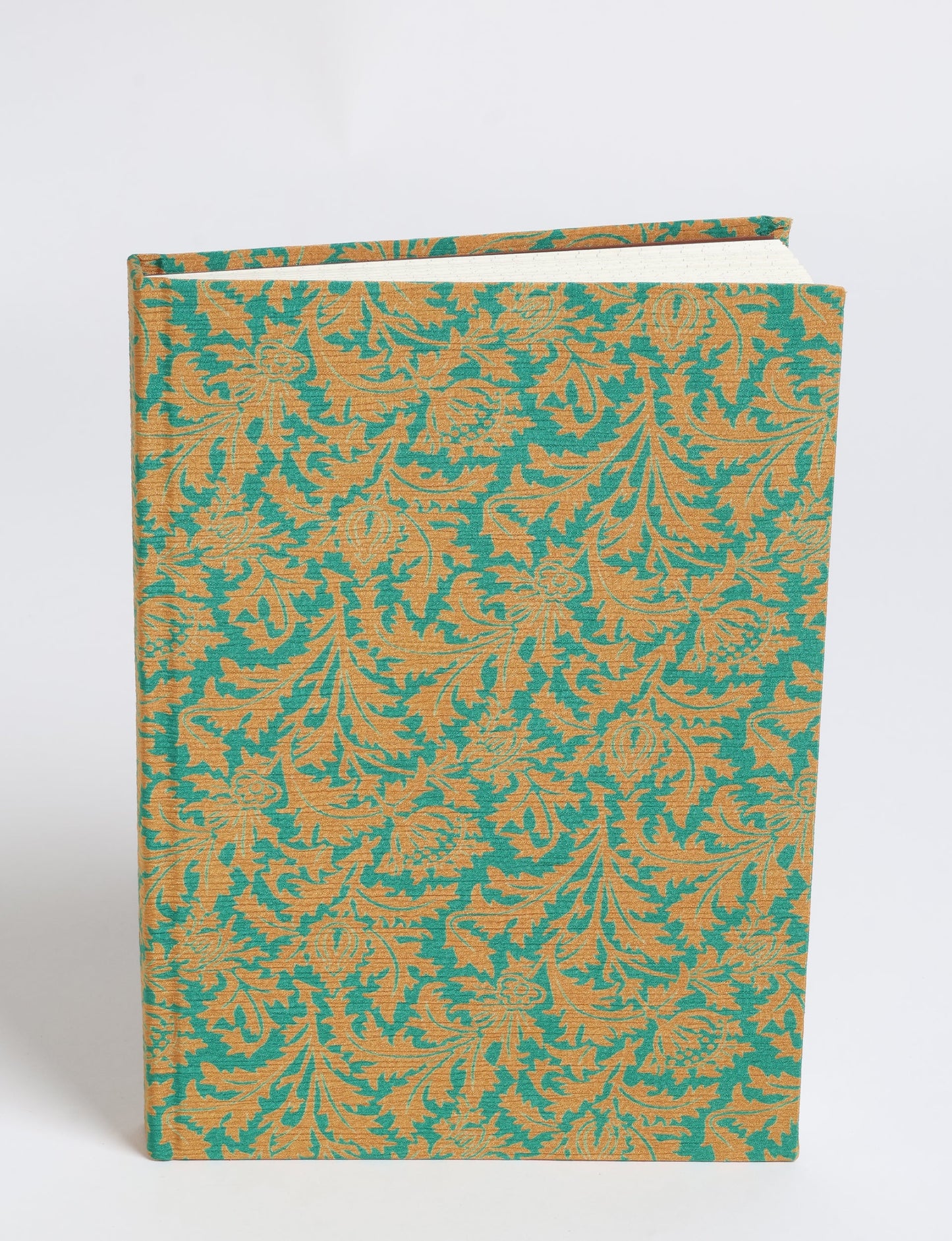 A5 hard cover notebook with green and gold leaf pattern fabric cover, shown standing upright with pages visible