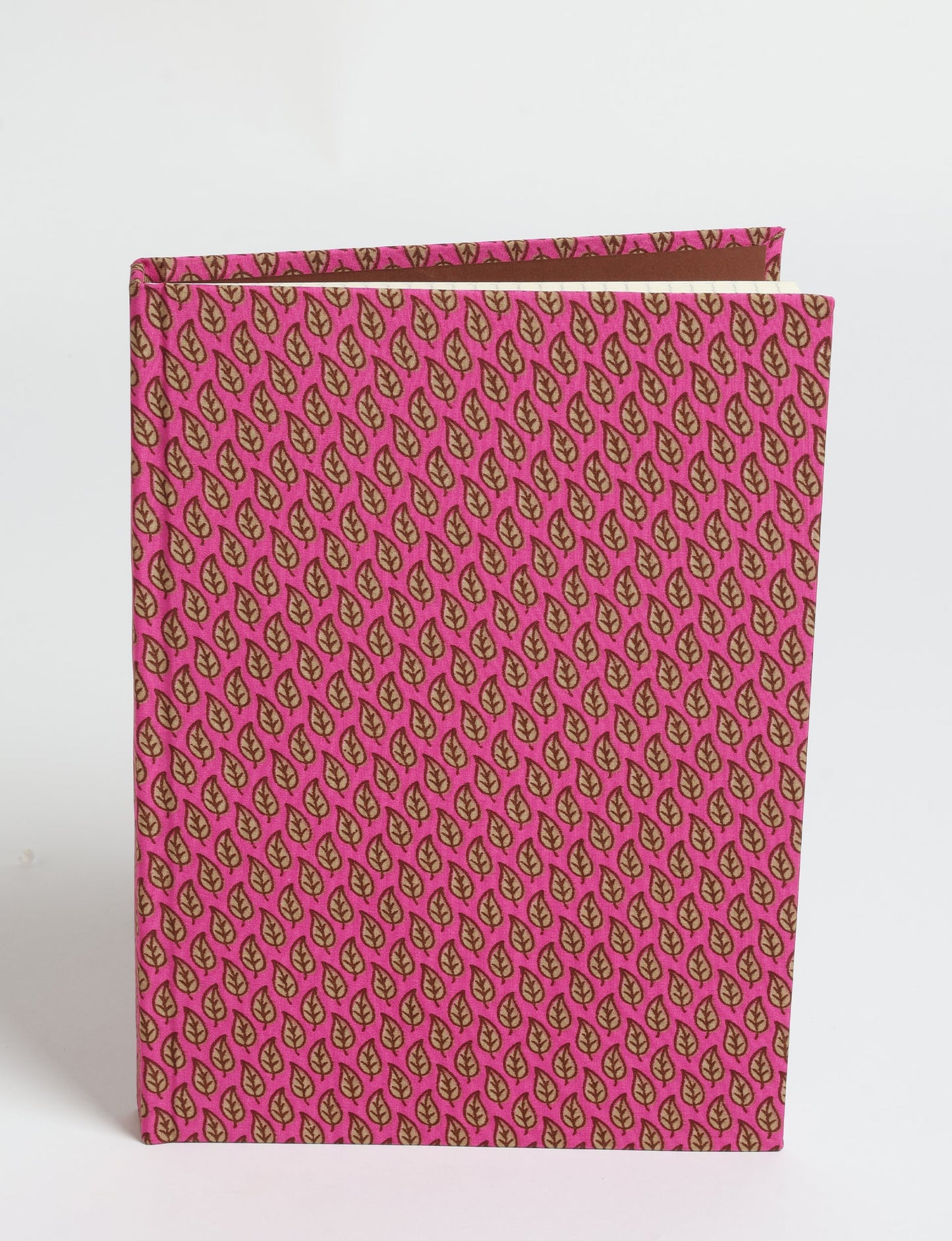 A5 hard cover notebook with pink fabric cover featuring a repeating pattern of small brown leaves, shown standing upright