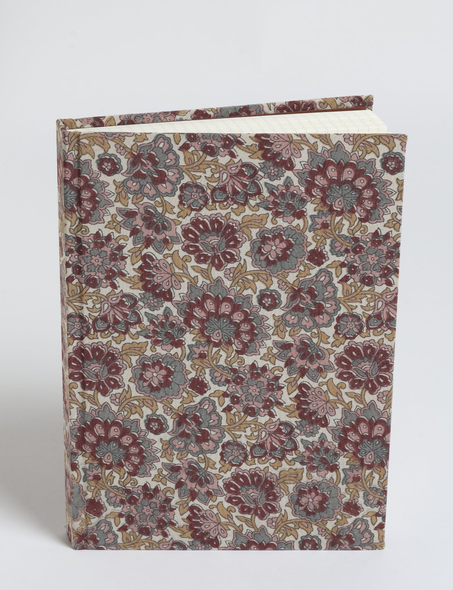 A5 hard cover notebook with beige fabric cover featuring red, pink, gray, and mustard floral pattern, shown standing upright
