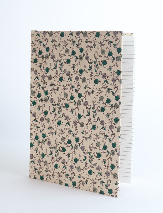 A5 hard cover notebook with green fabric cover featuring brown floral pattern, shown standing open with grid pages visible